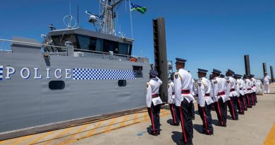 Members of the Gizo crew stand at attention while the Solomon Island national flag is raised for the first time on their new patrol boat, at Austal Shipyards, Western Australia. Photo by Leading Seaman Kylie Jagiello.