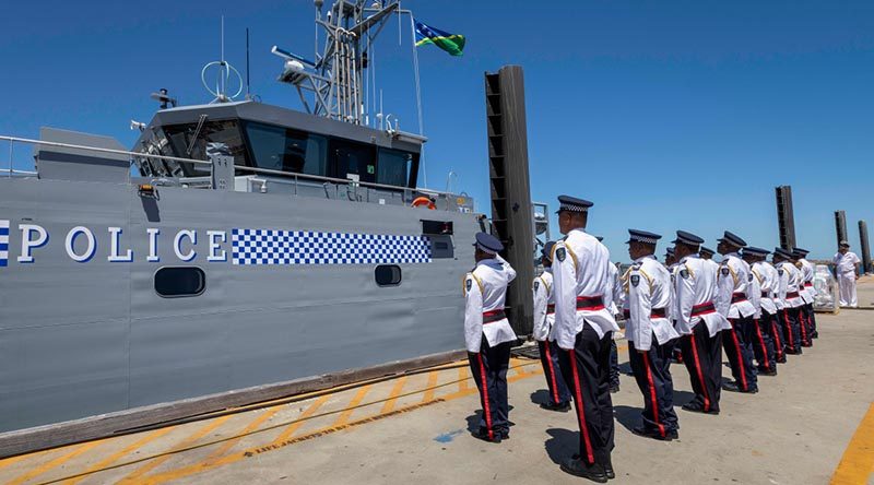 Members of the Gizo crew stand at attention while the Solomon Island national flag is raised for the first time on their new patrol boat, at Austal Shipyards, Western Australia. Photo by Leading Seaman Kylie Jagiello.