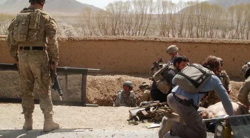 David Savage, right, lies injured on the ground after the blast that nearly killed him in the Chora Valley, Afghanistan, in 2012. Photo supplied by David Savage to the ABC.