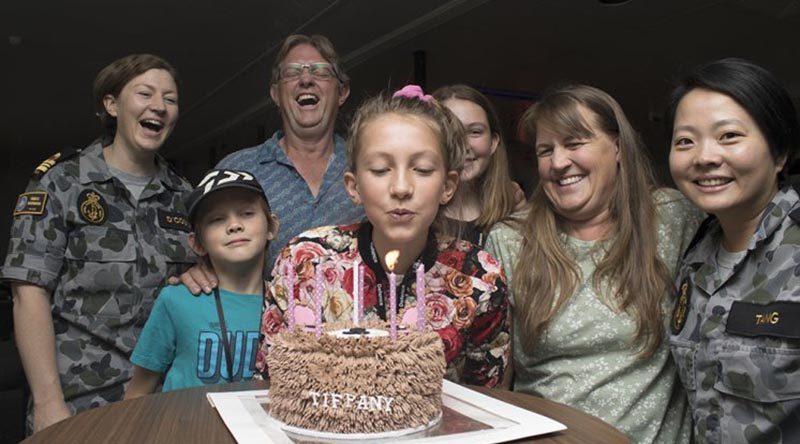 The Bragg family celebrate Tiffany's 12th birthday with their new Navy friends at the HMAS Harman bushfires evacuation centre.Photo by Lieutenant Ben Robson.