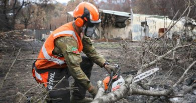 Private Jake Jubelin, an Army Reserve infantryman from the 2nd/17th Battalion, Royal NSW Regiment, cuts apart a fallen tree to restore access to a burn-out property. The owner’s home (background) was destroyed by bushfire, with the elderly couple forced to share a tent until access for a new caravan was restored by the Army. Photo by Major Cameron Jamieson