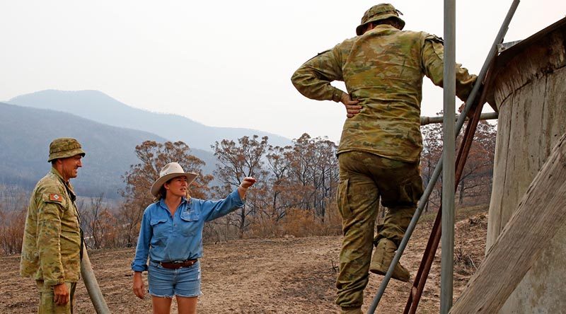 Australian Army soldiers Private Daniel Muntz (left) and Private Brendan Harvey deliver 9000 litres of water to remote-property owner Donna Thomson, who's water pump was destroyed by bushfires, leaving her, her family and her livestock dangerously short of water. The soldiers are from the Brisbane-based 7th Combat Service Support Battalion. Phot and story by Sergeant Dave Morley.