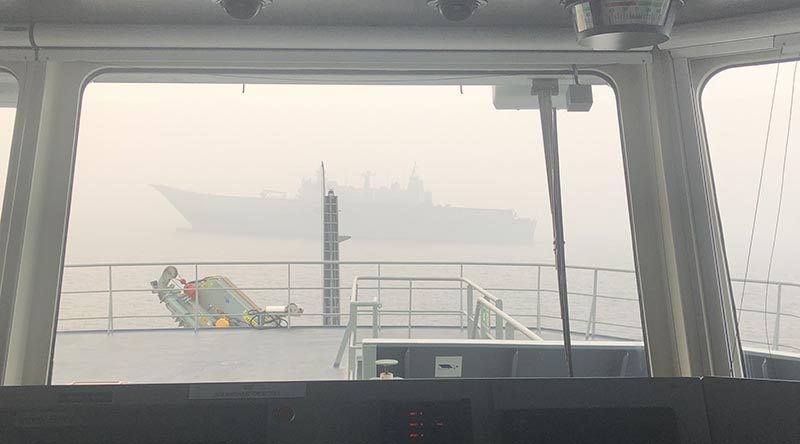 HMAS Adelaide as seen through the bridge window of MV Sycamore in Twofold Bay, New South Wales. Photo by Commander Brinckmann.