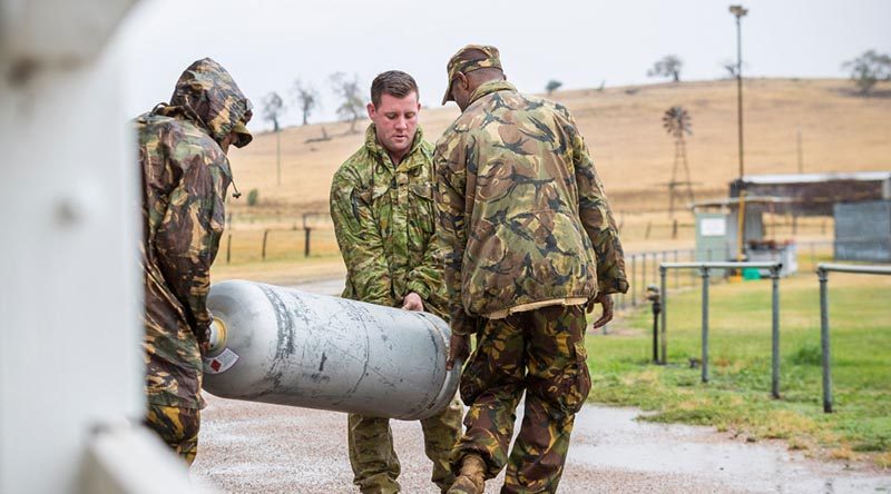 3rd Combat Engineer Regiment's Sapper Luke Simmonds helps Papua New Guinea Defence Force soldiers move a gas bottle at the Benambra Recreation Area. Photo by Corporal Sebastian Beurich.