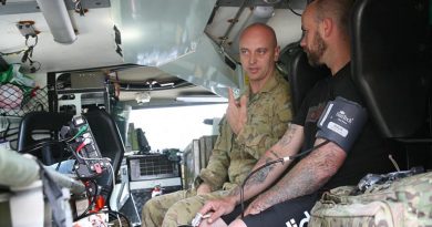Private Brenden Walker, in a Bushmaster ambulance, gives Jay Twemlow a check-up during a health visit to Batlow, NSW. Photo by Major Cameron Jamieson.