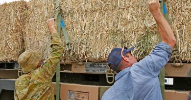 Private Shaun Whitehurst and Cooma farmer George Walters load fodder onto Private Whitehurst's truck for distrution to farmers on the New South Wales south coast. Photo by Sergeant Dave Morley.