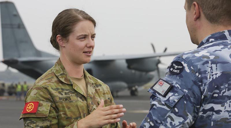 Army Corporal Ashton Brooks, from the Joint Movement Control Office, liaising with an Air Force member during the dispatch of supplies. Photo by Corporal Kylie Gibson