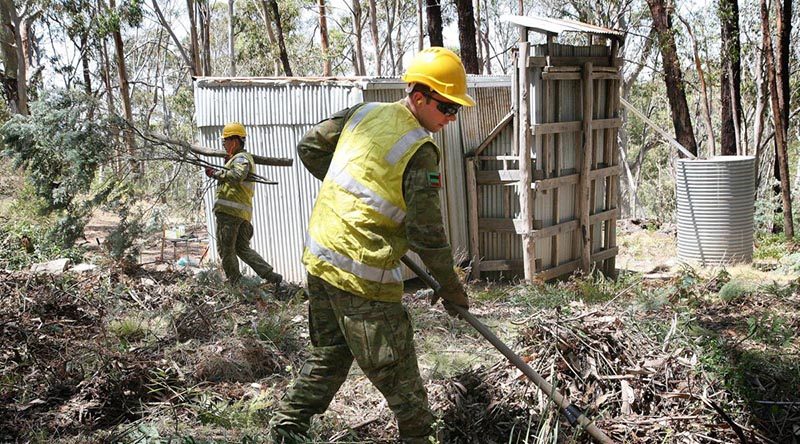 Private Ben Keogh uses a fire rake to clear vegetation away from the historic Bendora hut, located high in the Namadgi National Park in the ACT. Photo by Major Cameron Jamieson.