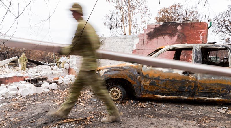 Soldier from the 12th/40th Royal Tasmanian Regiment clear debris from a home on Kangaroo Island that burnt down in the bushfires. Photo by Lance Corporal Brodie Cross.