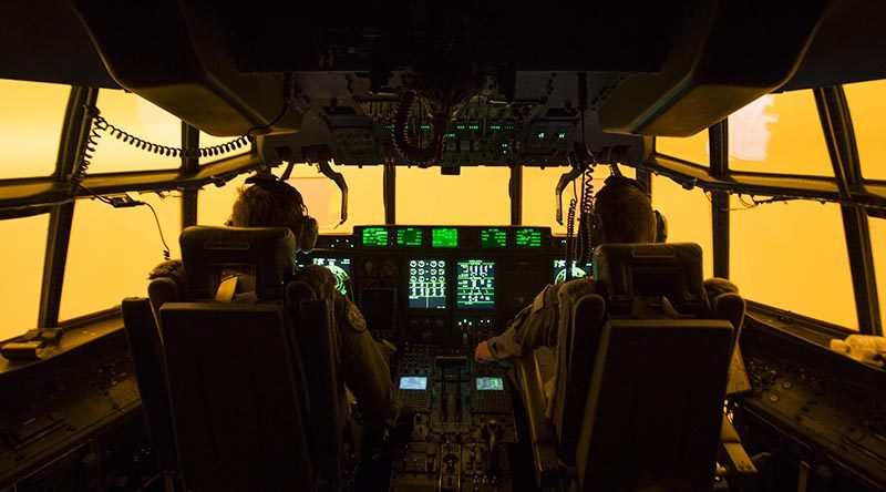 The flight deck glows orange from bushfire smoke as the crew of a Royal Australian Air Force C-130J Hercules attempts to land at Merimbula airfield to deploy fire and rescue crews to assist fighting the bushfires. Photo by Sergeant Christopher Dickson.