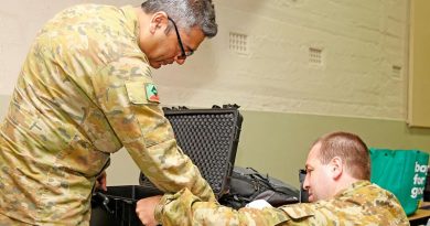 Australian Army Reserve Privates Syed Mairoj Hussainy and Aaron Clarke set up a Department of Human Services POP machine to give a mobile Centrelink disaster relief team secure online communications, at Batlow, New South Wales. Photo by Sergeant Dave Morley.