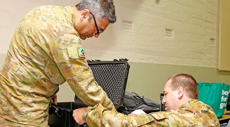 Australian Army Reserve Privates Syed Mairoj Hussainy and Aaron Clarke set up a Department of Human Services POP machine to give a mobile Centrelink disaster relief team secure online communications, at Batlow, New South Wales. Photo by Sergeant Dave Morley.