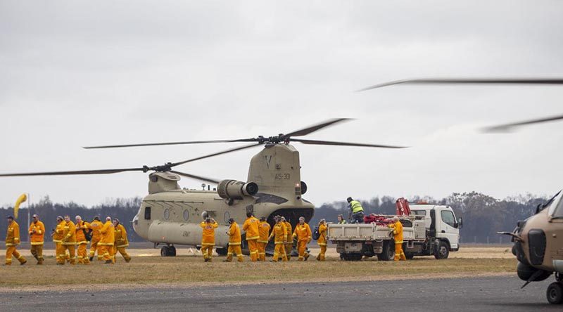 Victorian CFA firefighters arrive on an Australian Army CH-47 Chinook helicopter at Mallacoota. Photo: Corporal Nicole Dorrett.