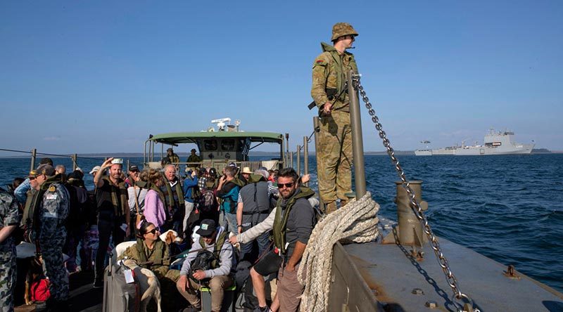 An LCM8 transits from HMAS Choules to HMAS Cerberus to disembark evacuees from Mallacoota during Operation Bushfire Assist 19-20 as the ship takes on supplies via the ship's MRH-90 helicopter. Photo by Petty Officer Helen Frank.