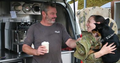 Ged Gross delivers the coffee while his Kelpie pup Tuna delivers the smiles for Captain Alisha Reeves in Bega. Photo by Major Cameron Jamieson.