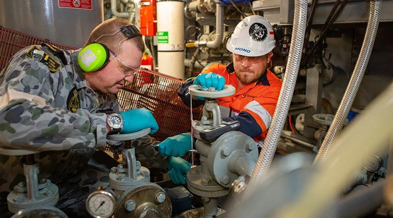 Leading Seaman Mark Curtis and Shadbolt contractor Scott Reid perform maintenance on the sewage-treatment plant of HMAS Adelaide during Operation Bushfire Assist 19-20. Photo by Petty Officer Tom Gibson.