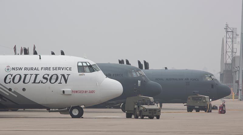 A NSW Rural Fire Service C-130 Hercules sits along side Royal Australian Air Force C-130J Hercules on the tarmac at RAAF Base Richmond during Operation Bushfire Assist 19-20. Photo by Sergeant Christopher Dickson.