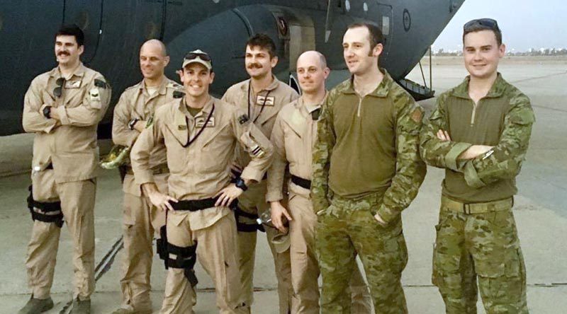 The crew of Mambo 21 stand in front of a Royal Australian Air Force C-130J Hercules at Baghdad International Airport. Flight Lieutenant Brendan Carraro, the aircraft captain, is pictured third from the left (wearing a cap).