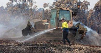 An Australian Army Combat Engineer from the 5th Engineer Regiment uses a JD-450 Bulldozer to spread burnt woodchips at the Eden Woodchip Mill in southern NSW in support of Operation Bushfire Assist 19-20. Photo by Sergeant Max Bree.