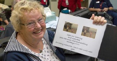 Maureen Jewell with a photo book created by her granddaughters detailing their experiences during the bushfires in Mallacoota, Victoria. Photo by Leading Aircraftman John Solomon.