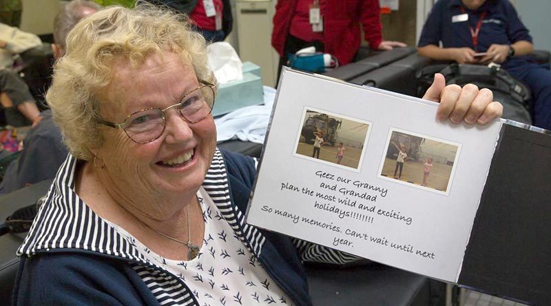 Maureen Jewell with a photo book created by her granddaughters detailing their experiences during the bushfires in Mallacoota, Victoria. Photo by Leading Aircraftman John Solomon.