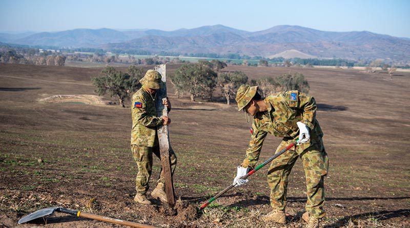 Australian Army Private Leonel Salilin (left) from 5th/6th RVR and Private DaWit Htoo, 8th/7th RVR, remove fire-affected fence posts on Operation Bushfire Assist 19-20. Photo by Trooper Jonathan Goedhart.