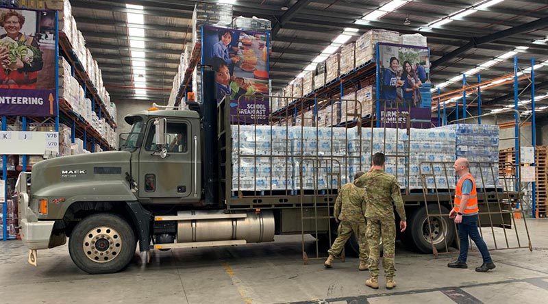 Soldiers from 15 Force Support Squadron load pallets of water at the Foodbank Victoria warehouse in Melbourne. Photo by Corporal Sebastian Beurich.