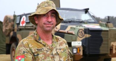 Lance Corporal Trent Hewitt in front of a Bushmaster Protected Mobility Vehicle – Ambulance at the evacuation centre in Batemans Bay, NSW. Photo by Sergeant Max Bree.