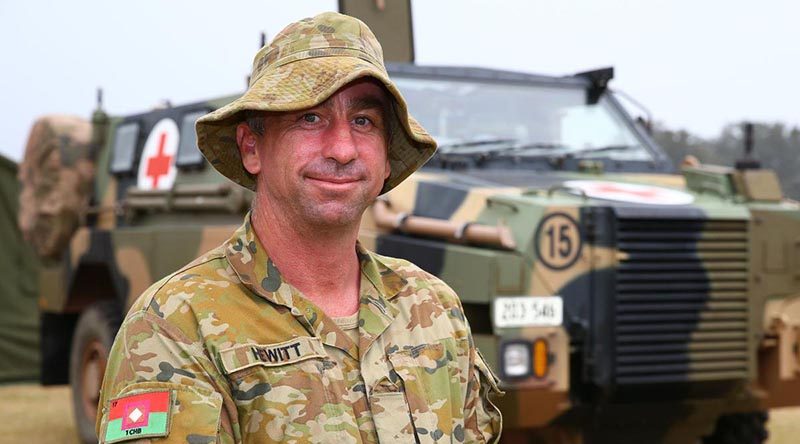 Lance Corporal Trent Hewitt in front of a Bushmaster Protected Mobility Vehicle – Ambulance at the evacuation centre in Batemans Bay, NSW. Photo by Sergeant Max Bree.