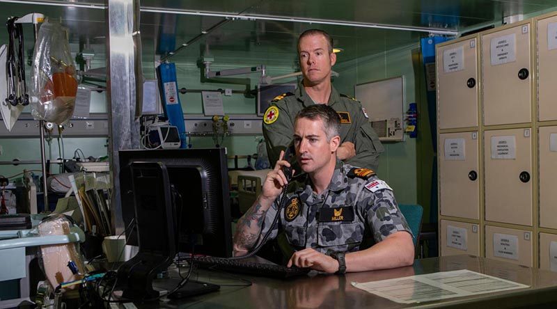 Embarked nursing officers Lieutenant Commander Thomas Miller (front) and Lieutenant Travis Robinson in HMAS Adelaide's treatment room. Photo by Able Seaman Thomas Sawtell.