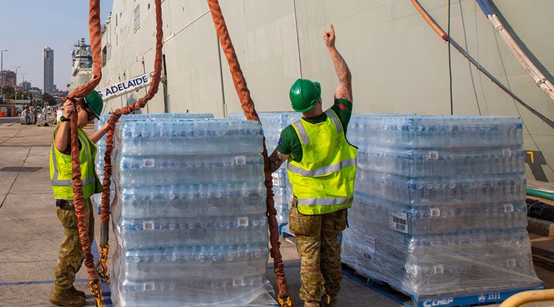 Cargo specialists Private Travis Elliot and Private Eboni Fraser load pallets of fresh water onto HMAS Adelaide at Fleet Base East, Sydney, in preparation to sailing as part of Operation Bushfire Assist 19-20. Photo by Able Seaman Benjamin Ricketts.