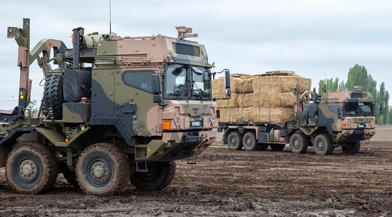 Australian Army HX77 heavy rigid vehicles load up with fodder near Cooma, NSW, for delivery to fire-affected farms. Photo by Sergeant Brett Sherriff.