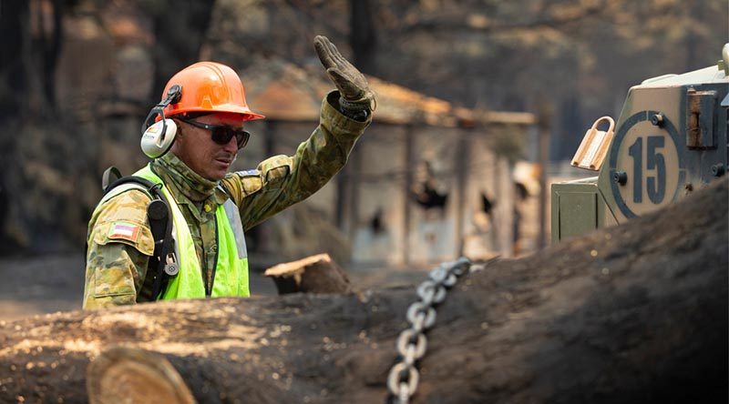 Corporal Dan Conelly, an Army Reservist from 3rd Field Squadron, 10th/27th Battalion, Royal South Australia Regiment, works to remove a burnt tree from a farm’s access road on Kangaroo Island. Photo by Corporal Tristan Kennedy.