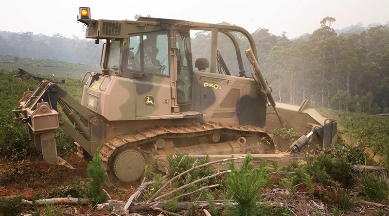 Bulldozer operator Leading Aircraftswoman Natasha Radford uses a JD 850J bulldozer to build a fire containment line at Bando Forest near Tumut to help protect remaining commercial timber essential to the economic viability of the region. Photo by Major Cameron Jamieson.