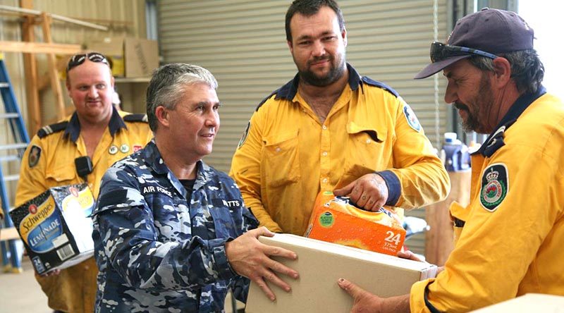 Corporal Shane Watts from 65 Squadron delivers meals and soft drinks to RFS volunteers in the fire grounds. Photo and story by Major Cameron Jameison.