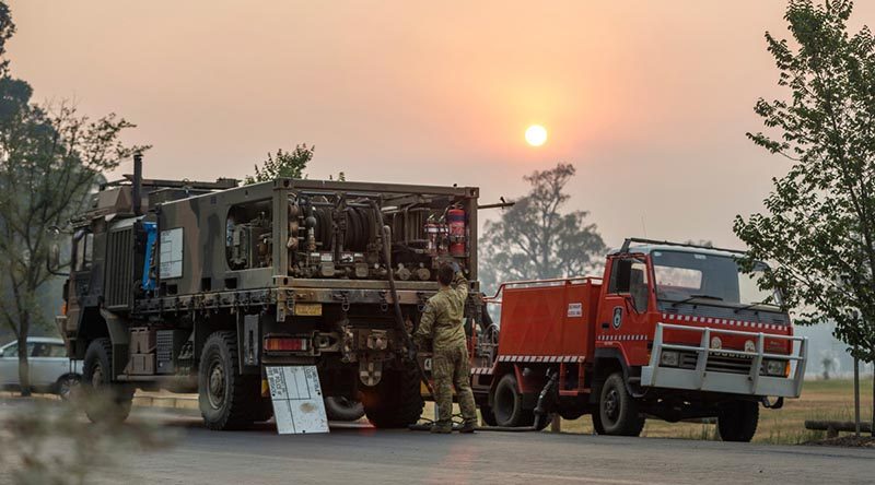 Private Richard Crisp from the Australian Army's 2nd Combat Engineer Regiment conducts morning checks and prepares to refuel a NSW Bush Fire Service vehicle near Tumut, NSW. Photo by Lance Corporal Brodie Cross.