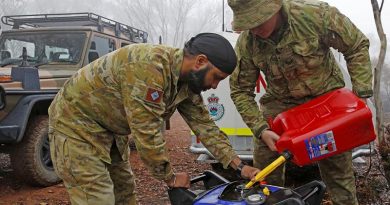 Private Manpreet Singh and Corporal Luke Ford of the Brisbane-based 7th Combat Services Support Battalion refuel a generator that powers a remote and vital RFS radio-relay antenna. Photo by Sergeant Dave Morley.
