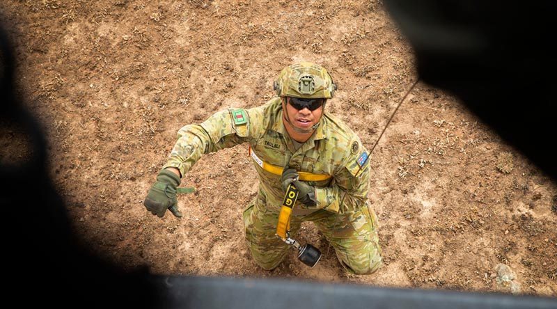 Australian Army Private Tauiliili from the 7th Battalion, Royal Australian Regiment, signals he is secure and ready to be winched up to a New Zealand Air Force NH90 helicopter in Canberra during Operation Bushfire Assist 19-20. Photo by Major Cameron Jamieson.