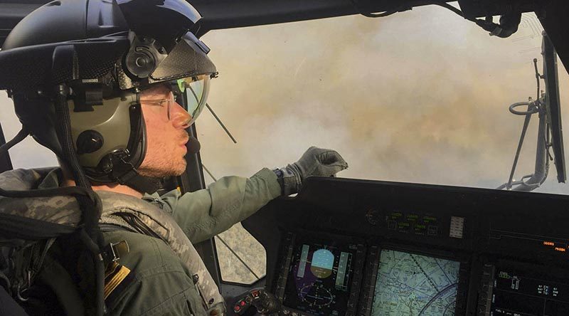 Royal Navy Pilot Lieutenant Commander Nick Grimmer in an 808 Squadron MRH90 Taipan helicopter over the Grose Valley bushfire in the Blue Mountains National Park. Photo by Chief Petty Officer Brett Kennedy.