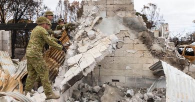 Soldiers from the 12th/40th Royal Tasmanian Regiment knock over a damaged wall of a home destroyed by bushfires on Kangaroo Island. Photo by Lance Corporal Brodie Cross.