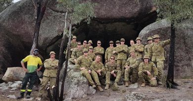 Soldiers from 6RAR with ACT Parks and Conservation Service Aboriginal field officer Kie Barratt at one of the important heritage sites they helped protect from recent bushfires. Photo by Lieutenant Jack Membrey.