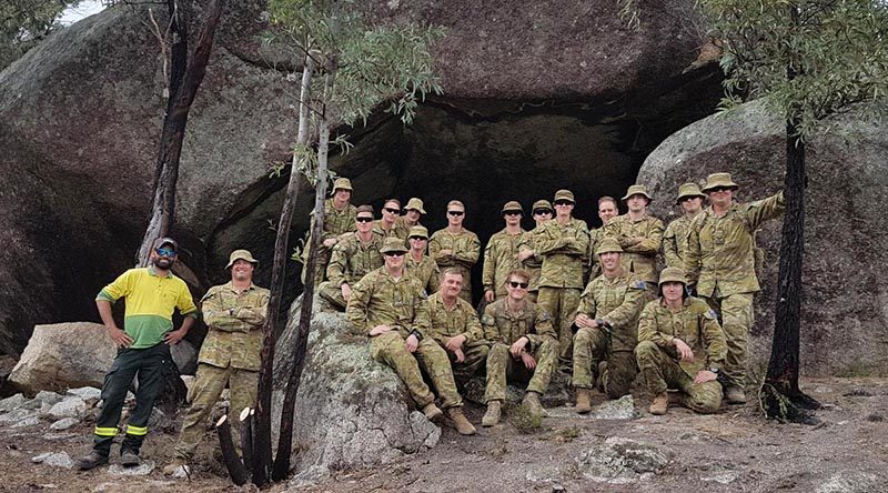 Soldiers from 6RAR with ACT Parks and Conservation Service Aboriginal field officer Kie Barratt at one of the important heritage sites they helped protect from recent bushfires. Photo by Lieutenant Jack Membrey.