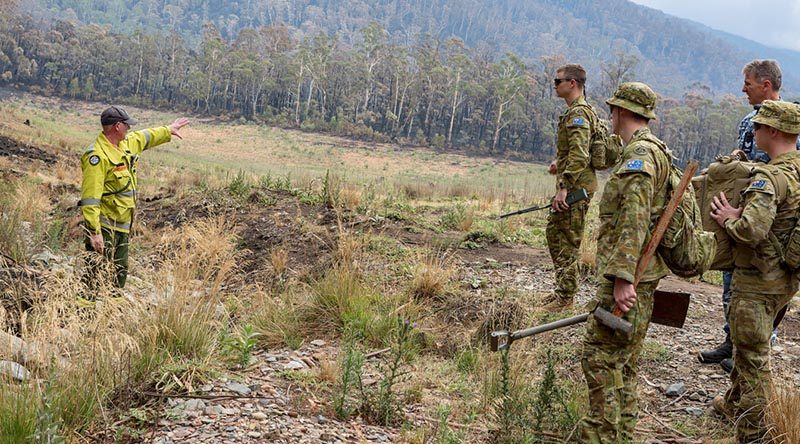 Soldiers from 6RAR are briefed by Scott Seymour from the ACT Environmental Services Agency before laying sediment traps in water-flow lines of the Corin Dam catchment in Namadgi National Park during Operation Bushfire Assist. Photo by Corporal Dan Pinhorn.