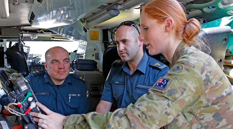 Australian Army Reservist Private Sam Cantle, a combat medical attendant with the Sydney-based 5th Combat Services Support Battalion gives familiarisation tips on the Bushmaster ambulance vehicle to ACT Ambulance Service officers John Berry (left) and Paul Haines at Fairbairn, Canberra. Photo by Sergeant Dave Morley.