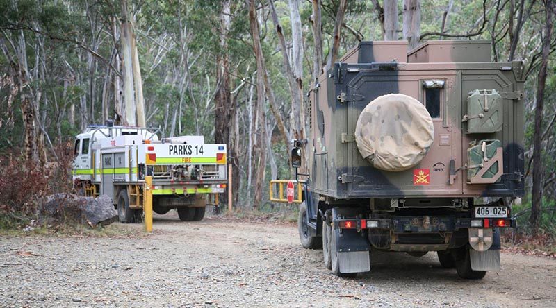 An Australian Army G-Wagon six-wheel-drive ambulance follows an ACT fire truck onto Mt Franklin Road for the drive to the edge of the Orroral Valley fire. Photo by Major Cameron Jamieson.