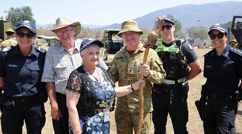 Police Chaplain Carol Allen presents the shepherd's crook to Chaplain Robert Packer, flanked by Ian Post, second from left, and members of Victoria Police. Photo by Private Stuart Rayner.