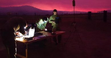 Royal Australian Artillery soldiers gather around their workstation as they guide their AE Wasp III Small Unmanned Aircraft System over the Orroral Valley fire in the south of the ACT. Photo: Captain Shaun Montgomery