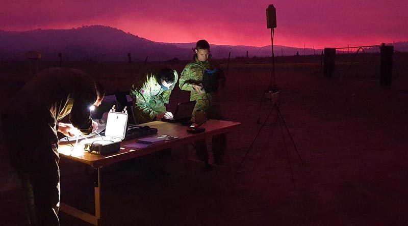 Royal Australian Artillery soldiers gather around their workstation as they guide their AE Wasp III Small Unmanned Aircraft System over the Orroral Valley fire in the south of the ACT. Photo: Captain Shaun Montgomery