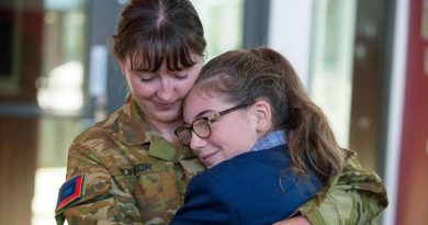 Corporal Marie Yorston and her niece, Allee, hug after their surprise reunion on her first day of high school. Photo by Private Michael Currie.