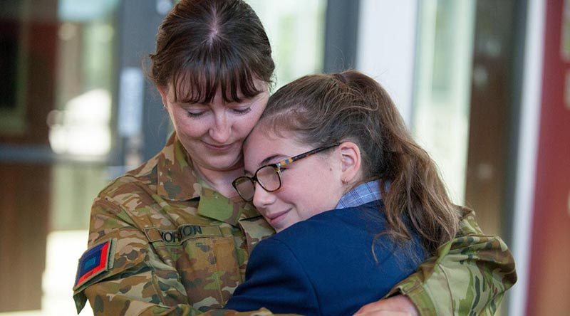 Corporal Marie Yorston and her niece, Allee, hug after their surprise reunion on her first day of high school. Photo by Private Michael Currie.